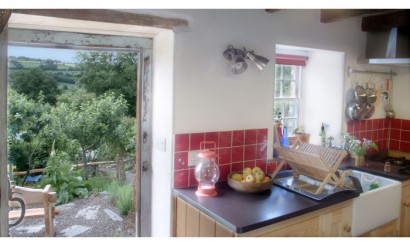 The kitchen and view to the garden. Photo from Under the Thatch